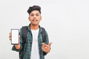 Young indian college student showing smartphone Screen on white background. photo