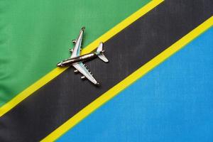 avión sobre la bandera de tanzania el concepto de viajes y turismo. foto