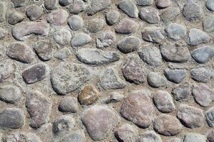 Grey cobblestone texture of a ground with many stones