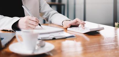 Business woman calculating domestic expenses involved in financial paperwork indoors, focused lady managing monthly banking payments summarizing utility bills and taxes at home photo