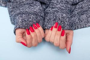 Red matte manicure on female hands for valentines day photo