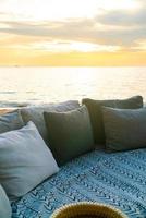 pillows on outdoor patio deck chair on beach with sunset times photo