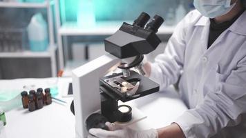 wissenschaftler, der mikroskop für studienforschung im wissenschaftslabor, wissenschaftliche medizinausrüstungstechnologie im chemie- und biologieexperiment verwendet