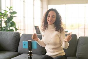 Latin woman influencer shooting video and talking with camera for blog photo