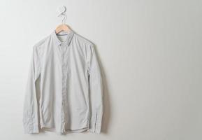 hanging shirt with wood hanger on wall photo