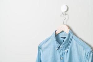 hanging shirt with wood hanger on wall photo