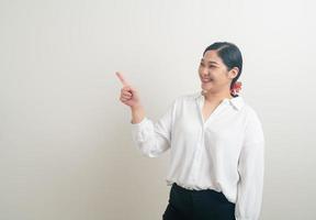 Mujer asiática con la mano apuntando sobre fondo blanco. foto