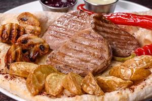 Delicious juicy chicken steak with baked potatoes, mushrooms and sauces photo