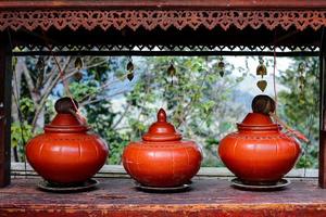 Three pieces of classic style orange pottery water jar on table outdoor. photo