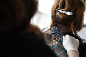 woman client person having a process to making treatment a hair with hairdresser in beauty salon photo