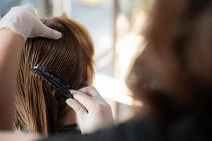 mujer cliente persona que tiene un proceso para hacer que el tratamiento sea un cabello con peluquero en un salón de belleza foto