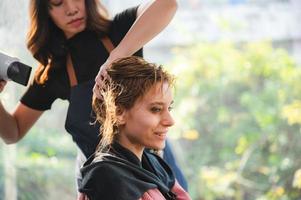 woman client person having a process to making treatment a hair with hairdresser in beauty salon photo