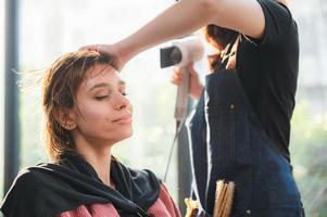 woman client person having a process to making treatment a hair with hairdresser in beauty salon photo