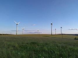 centrales eléctricas de turbinas eólicas en la colina de hierba foto