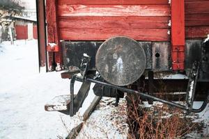 Old red wooden train car back side with metal buffer photo