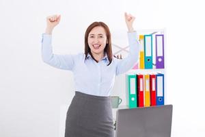 Happy and successful businesswoman raising her arms at office background and celebrating success isolated on white. mock up and copy space. Business concept photo