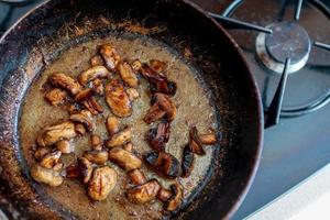 beautiful fried mushrooms champignon in background cast iron pan photo