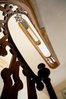 Ver de abajo hacia arriba en una hermosa escalera de lujo con barandas de madera foto