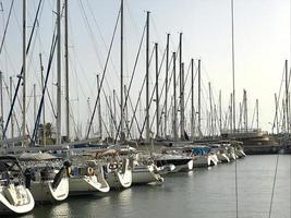 Beautiful yacht ship moored at port with other boats on blue salted sea photo