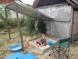 Hermoso bebé en el arenero infantil posando fotógrafo cerca del arenero foto