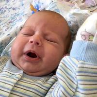 Sleeping baby boy with child clothes posing photographer for color photo