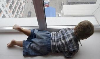 Beautiful baby boy with child face posing photographer near window photo