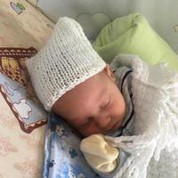 Beautiful sleeping baby boy with child hat posing photographer for color photo