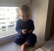 Beautiful baby boy with child face posing photographer near window photo