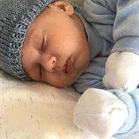 Beautiful sleeping baby boy with child hat posing photographer for color photo