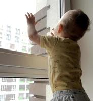 Beautiful baby boy with child face posing photographer near window photo