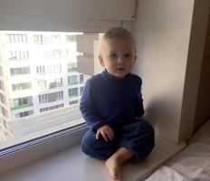 Beautiful baby boy with child face posing photographer near window photo