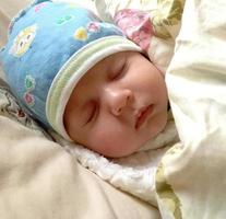 Beautiful sleeping baby boy with child hat posing photographer for color photo