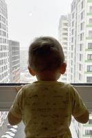 Beautiful baby boy with child face posing photographer near window photo