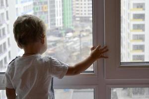 Beautiful baby boy with child face posing photographer near window photo