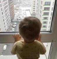 Beautiful baby boy with child face posing photographer near window photo