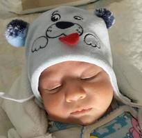 Beautiful sleeping baby boy with child hat posing photographer for color photo