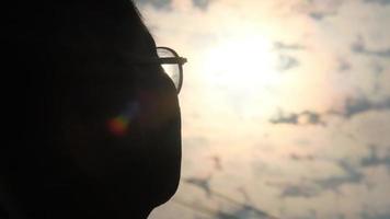silhueta de um homem sênior, olhando para longe à luz do sol da noite. um homem sênior feliz ao pôr do sol. video