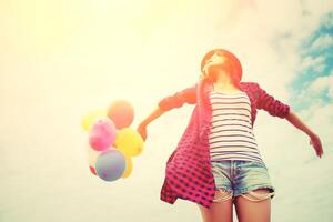 Hermosa joven sosteniendo un globo muy feliz al aire libre foto