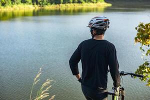 Athletes stand on the mountains and rivers with bicycle photo