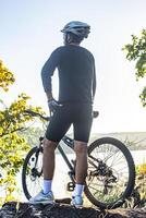 Athletes standing on the mountains with bicycle photo