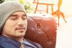 handsome hipster man take a nap on his sofa in the house photo