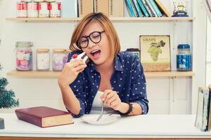 joven hipster sentada en el café comiendo pastel tan feliz foto