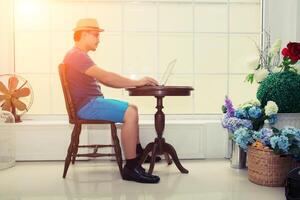 handsome businessman working with laptop near the window in the living room at the morning photo