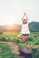 Young beautiful woman is practicing yoga at mountain view in the morning. photo