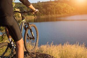 ciclista en la cima de la montaña del lago, vida extrema y de aventura. foto