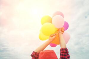 Hermosa joven sosteniendo un globo muy feliz al aire libre foto