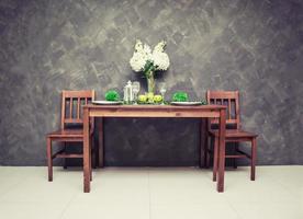 Sweet wooden dining table and chair with the wine glass and fruit on the table