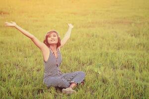 Beautiful sexy woman sitting  listening music from headphone smiley enjoying music in the grass field photo