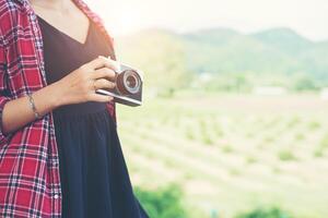 Young hipster woman photographer holding a vintage camera. photo