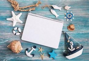 Shells and notepad on wooden table photo